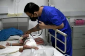 Un médecin examine un enfant à l'hôpital d'Angkor, le 6 juillet 2022 à Siem Reap, au Cambodge