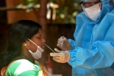 Un personnel médical portant un équipement protectif teste un femme au Covid-19 le 26 août 2020 à Siliguri en Inde