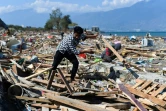 Un survivant du séisme meurtrier qui a frappé Palu sur l'île des Célèbes en Indonésie tente de récupérer des objets dans les décombres, le 1er octobre 2018