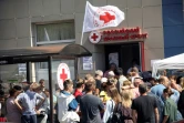 Des personnes déplacées par les combats reçoivent une aide humanitaire au point de distribution de la Croix-Rouge russe à Koursk, le 15 août 2024