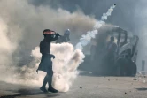 Un manifestant utilise une raquette pour renvoyer une grenade lacrymogène lors de heurts avec la police, le 8 août 2020 à Beyrouth