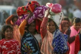 Des pèlerins hindous transportant leurs affaires arrivent à Sangam avant le festival de la Kumbh Mela à Prayagraj en Inde, le 11 janvier 2025