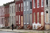 Un américain passe devant des maisons murées à l'est de Baltimore, le 8 août 2017