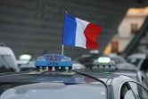 Un drapeau tricolore sur un taxi dont le chauffeur manifeste le 26 janvier 2016 à Paris