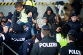 Des policiers autrichiens aident des migrants à franchir la frontière entre l'Autriche et le Hongrie le 20 septembre 2015 à Nickelsdorf