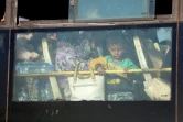 Des familles syriennes évacuées par bus de la province de Qouneitra arrivent au passage de Morek, le 21 juillet 2018 avant d'être emmenées vers les provinces d'Idleb et d'Alep