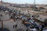Des déplacés palestiniens  attendent près du passage de Netzarim, qui coupe la bande de Gaza en deux, avant de pouvoir regagner le nord du territoire, le 26 janvier 2025
