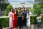 Une famille pose au côté d'un ancien combattant de la guerre du Vietnam devant le Palais de l'Indépendance, le 29 avril 2025 à Ho Chi Minh Ville