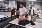 Un employé place des vêtements usagés sur une machine de tri sur le site du Cetia à Hendaye, dans les Pyrénées-Atlantiques, le 4 septembre 2023