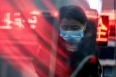 Une femme munie d'un masque respiratoire aux abords d'une gare de Pékin, le 22 janvier 2020
