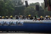 Des protestataires utilisent un gros tuyau comme barricade, lors d'une manifestation contre le coup d'Etat militaire en Birmanie, le 11 mars 2021 à Rangoun