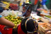 Un jeune garçon porte un masque en plexiglas au marché de San Cosme à Mexico le 10 août 2020
