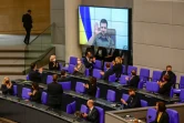 Le président ukrainien Volodymyr Zelensky applaudi par le chancelier allemand Olaf Scholz et les membres du Bundestag lors d'une intervention vidéo, le 17 mars 2022 à Berlin