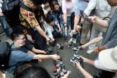 Des fans d'appareils photos argentiques montrent leurs appareils lors d'une visite guidée à Kamakura, le 29 juin 2024 au Japon