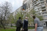 Des habitants observent un incendie dans un immeuble résidentiel à la suite d'un frappe, dans les faubourgs de Kharkiv (est de l'Ukraine), le 22 avril 2022