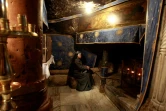 Une religieuse prie le 20 décembre 2016 devant la grotte de l'Eglise de la Nativité, où Jésus-Christ est né selon la tradition chrétienne, à Béthléem en Cisjordanie