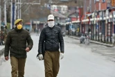 Des policiers portant des masques de protection dans une rue de Srinagar, au premier jour du confinement instauré en Inde pour lutter contre l'épidémie du nouveau coronavirus, le 25 mars 2020
