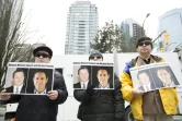 Des manifestants tiennent des photos de deux Canadiens interpellés en Chine, devant la Cour suprême de Vancouver, le 6 mars 2019 au Canada