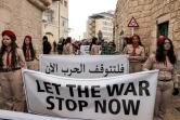 Des scouts palestiniens tiennent des banderoles appelant à la fin de la guerre entre Israel et le Hamas, le 24 décembre 2023 à Bethléem en Cisjordanie occupée