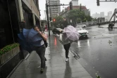 Des passants se débattent avec leurs parapluies au passage du typhon Bebinca, le 16 septembre 2024 à Shanghai