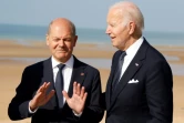 Le chancelier allemand Olaf Scholz (gauche) et le président américain Joe Biden échangent lors d'une cérémonie marquant le 80e anniversaire du Débarquement allié en Normandie, le 6 juin 2024 à Saint-Laurent-sur-Mer