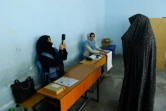 Une employée de la Commission électorale scanne le visage d'une votante lors des législatives, le 20 octobre 2018 à Hérat, en Afghanistan