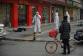 Les services de secours interviennent après le décès d'une personne (au sol) dans une rue de Wuhan, le 30 janvier 2020