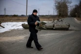 Un membre de la défense ukrainienne porte un fragment de missile pendant une observation des mouvements des troupes russes autour du village de Velyka Dymerka, à 40 km à l'est de Kiev, le 9 mars 2022
