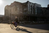 Un habitant  passe à vélo devant un restaurant détruit dans la ville de Pokrovsk, dans la région de Donetsk, le 19 novembre 2024