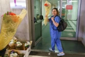 Un membre du personnel soignant de l'hôpital de Burgos (nord de l'Espagne) reçoit un bouquet de fleurs en signe de remerciement, le 21 mars 2020 