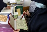 Des femmes restaurent des exemplaires du Coran, anciens ou abîmés, dans un atelier à Tripoli, le 22 mars 2022 en Libye