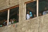 Des réfugiés syriens aux fenêtres d'un immeuble en construction qu'ils utilisent comme abri dans la ville de Saïda dans le sud du Liban, le 17 mars 2020 