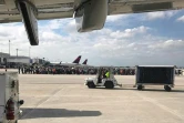 Des passagers rassemblés sur le tarmac de l'aéroport de Fort Lauderdale, en Floride, le 6 janvier 2017, théâtre d'une fusillade qui a fait cinq morts