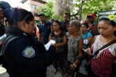 Une policière donne des informations aux femmes de prisonniers après une mutinerie, devant le commissariat de Valence, le 28 mars 2018 au Venezuela