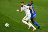 L'attaquant du Real Madrid Karim Benzema (g) à la lutte avec le défenseur de Getafe Allan Nyom, le 2 juillet 2020 à Valdebebas, dans la banlieue de Madrid 