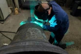 Un employé de l'entreprise Bodet effectue une soudure sur une cloche en réparation, le 17 décembre 2018 à Trémentines, dans le Maine-et-Loire en France