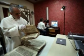 Le père Najeeb Michaeel examine un ancien manuscrit chrétien au Centre de numérisation des manuscrits orientaux (CNMO) à Erbil, dans le nord de l'Irak, le 1er mars 2018