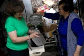 Ariana Nikolla (g) et Resmie Tuçi préparent de l'eau de rose de manière traditionnelle à Përmet, le 28 mai 2025 en Albanie