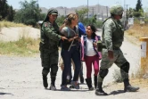 Des membres de la Garde nationale mexicaine arrêtent des femmes et une fillette s'apprêtant à franchir le Rio Bravo entre Ciudad Juarez au Mexique et El Paso aux Etats-Unis, le 21 juin 2019