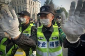 La police chinoise empêche les journalistes de filmer, le 28 décembre 2020, devant le tribunal de Shanghaï qui a condamné lundi la journaliste chinoise Zhang Zhan à 4 ans de prison pour ses reportages sur les débuts chaotiques du coronavirus à Wuhan