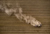Un tracteur soulève un nuage de poussière en labourant un champ près de Froideville (Suisse), le 26 juillet 2022