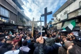 Des Syriens chrétiens brandissent des croix lors d'un rassemblement dans un quartier de Damas, le 24 décembre 2024