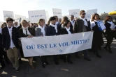 Ghyslain Wattrelos (3e à d), proche de victimes du vol MH370 de la Malaysia Airlines qui a disparu en mars 2014, en tête d'une marche silencieuse vers le Palais de l'Elysée à Paris, le 8 mars 2015