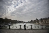 Une femme médite sur le Pont des Arts à Paris le 17 mars 2020, début du premier confinement lié à la pandémie de covid