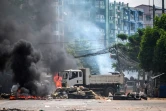 Des policiers mettent le feu à une barricade dans une rue de Rangoun le 19 mars 2021