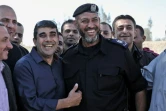 Un membre de l'Autorité palestinienne (G), sourit au côté d'un membre des forces de sécurité du Hamas, à Rafah, près de la frontière entre la bande de Gaza et l'Egypte, le 1er novembre 2017