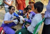 La chasseuse de serpents Shwe Lei donne les premiers soins à un garçon blessé dans le canton de Kyauktaga à Bago, le 26 mars 2023