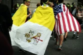 Des Américains avec le drapeau du Vatican et des Etats-Unis quittent l'endroit où le pape François a célébré une messe géante le 27 septembre 2015 à Philadelphie