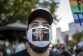 Un homme porte un  masque sur lequel est écrit "You're Fired Trump" ("Vous êtes viré Trump"), le 7 novembre 2020 à Austin au Texas