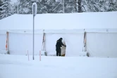 Un garde-frontière entre dans une tente chauffée réservée aux demandeurs d'asile qui pourraient arriver au poste frontalier de Raja-Jooseppi à Inari, dans le nord de la Finlande, le 28 novembre 2023